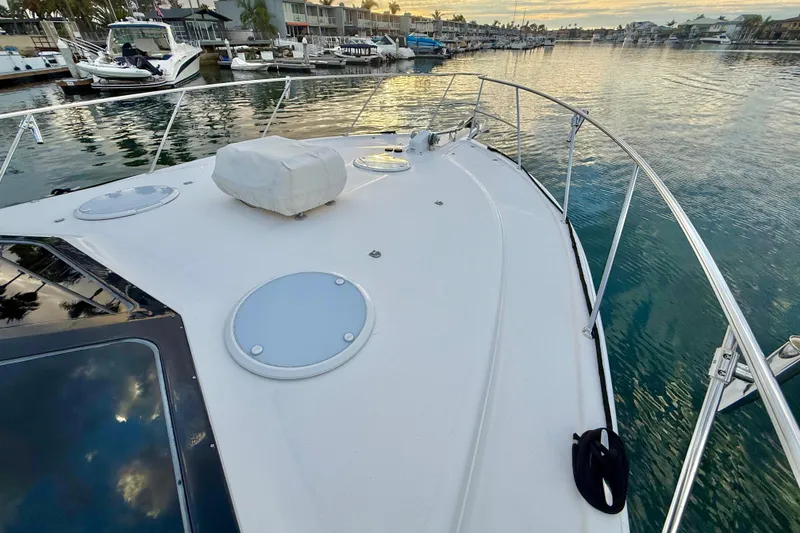Slide: The Image of 2001 Riviera 40 Flybridge yacht on calm water at sunset, docked in a marina. - 53