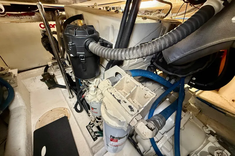 Slide: The Image of Engine room of a 2001 Riviera 40 Flybridge yacht, showcasing mechanical components and hoses. - 69