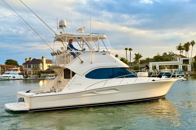 Slide: The Image of 2001 Riviera 40 Flybridge yacht cruising in a scenic waterfront setting. - 7