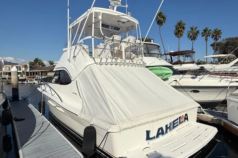 Slide: The Image of 2001 Riviera 40 Flybridge yacht docked at marina under clear blue sky. - 77