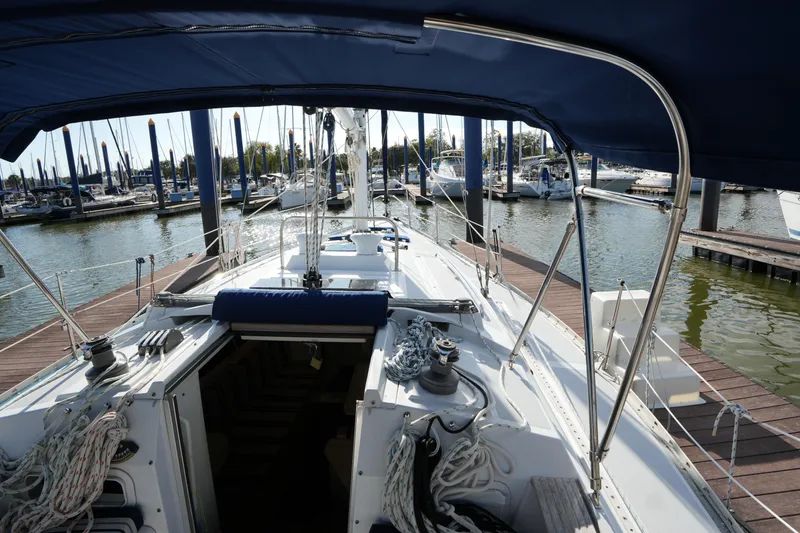 Slide: The Image of 1983 Hunter 34 sailboat docked at marina, view from cockpit under blue canopy. - 11