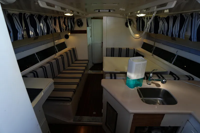 Slide: The Image of Interior of 1983 Hunter 34 sailboat with striped seating and compact kitchen area. - 13