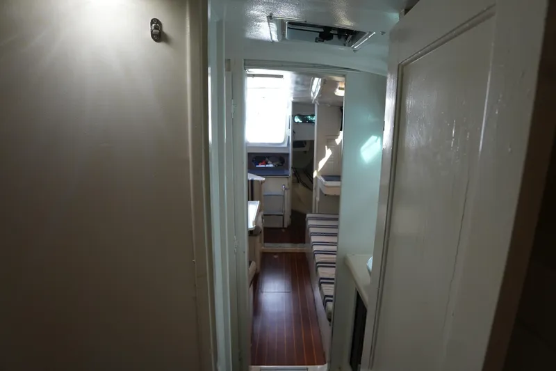 Slide: The Image of Interior view of 1983 Hunter 34 sailboat, featuring cozy cabin and striped seating. - 15