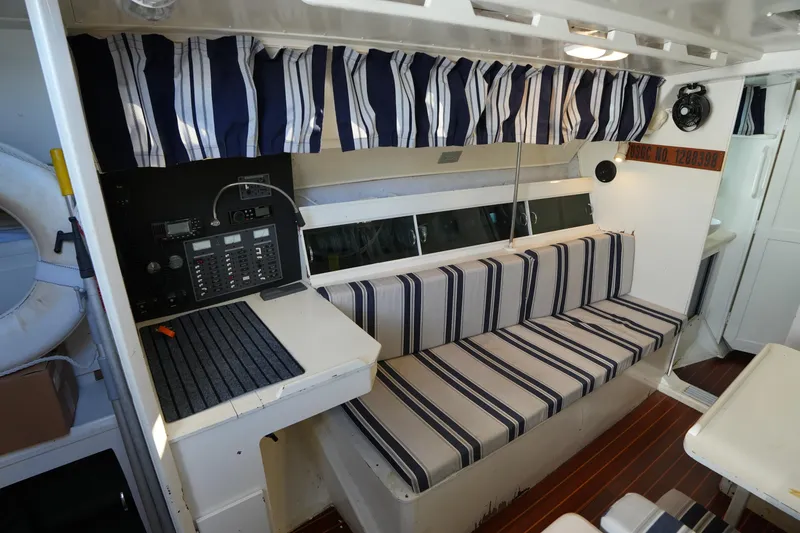 Slide: The Image of Interior of 1983 Hunter 34 sailboat with striped seating and navigation panel. - 19