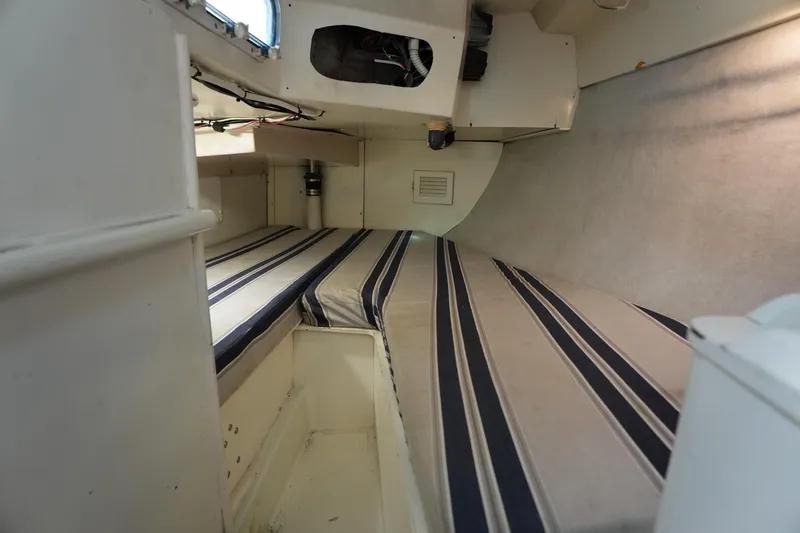 Slide: The Image of Interior cabin of 1983 Hunter 34 sailboat with striped cushions and storage space. - 24