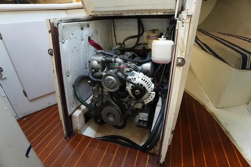 Slide: The Image of Engine compartment of a 1983 Hunter 34 sailboat, showcasing mechanical components and interior design. - 26