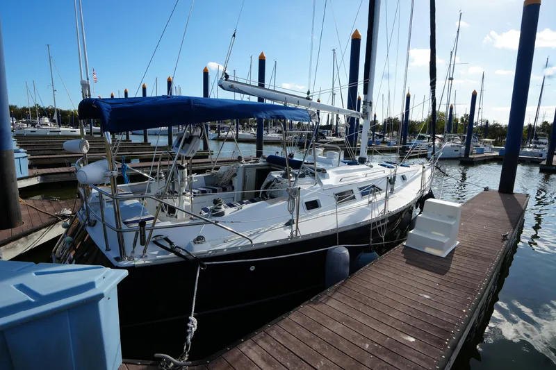 Slide: The Image of 1983 Hunter 34 sailboat docked at marina under clear blue sky. - 3