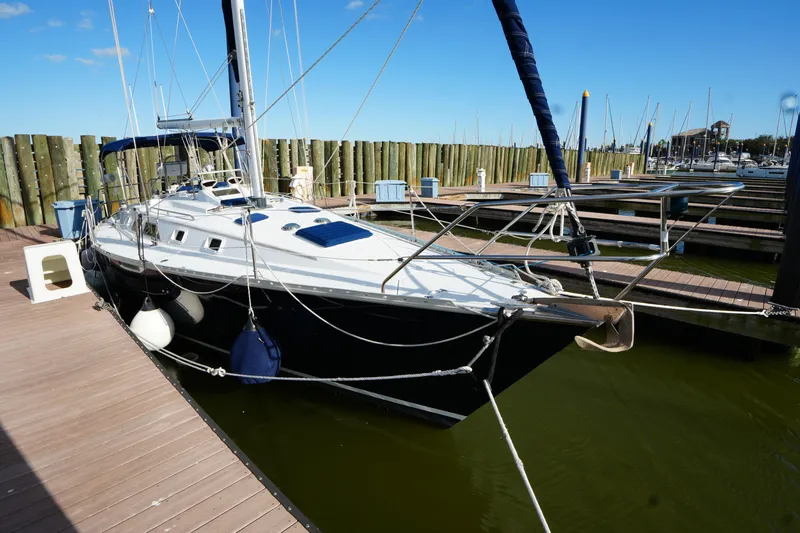 Slide: The Image of 1983 Hunter 34 sailboat docked at marina under clear blue sky. - 4