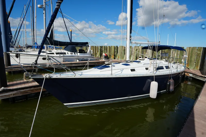 Slide: The Image of 1983 Hunter 34 sailboat docked at marina under blue sky. - 6