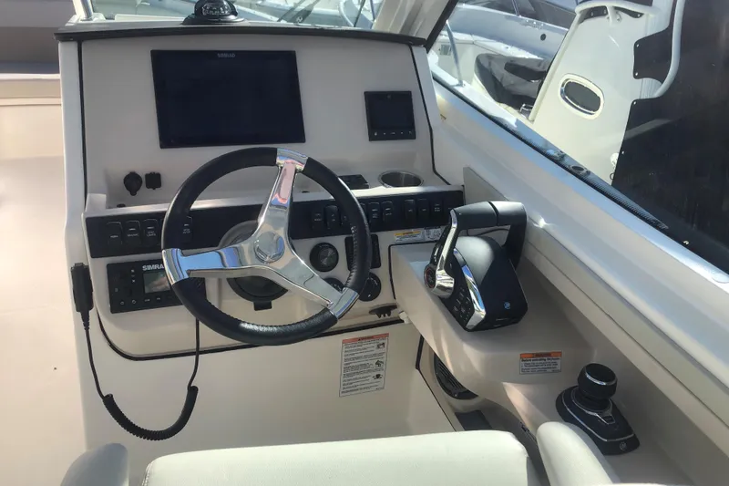 Slide: The Image of 2024 Boston Whaler 280 Vantage helm with steering wheel and control panel. - 11