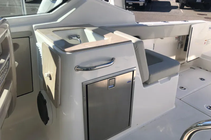 Slide: The Image of 2024 Boston Whaler 280 Vantage interior with sink, seating, and storage. - 5
