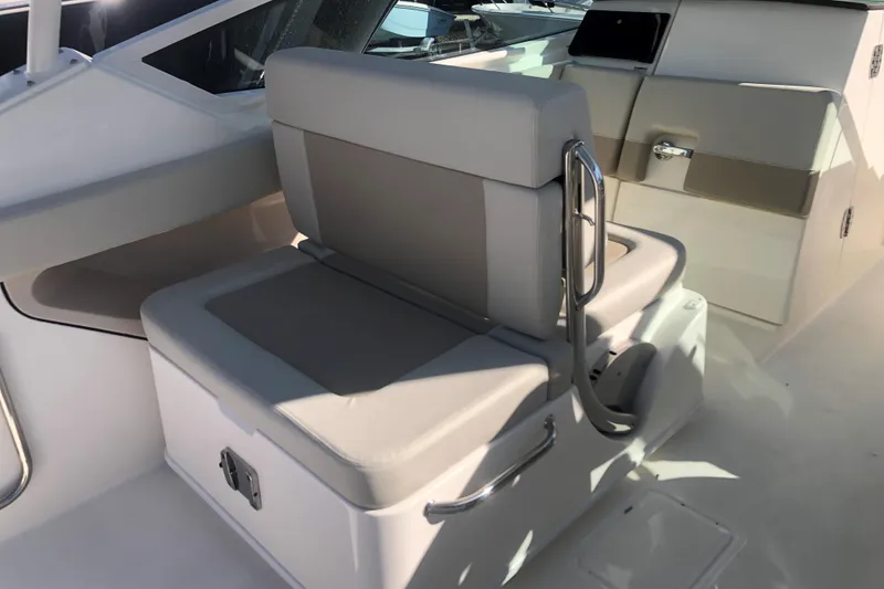 Slide: The Image of 2024 Boston Whaler 280 Vantage boat interior with cushioned seating and stainless steel handles. - 6