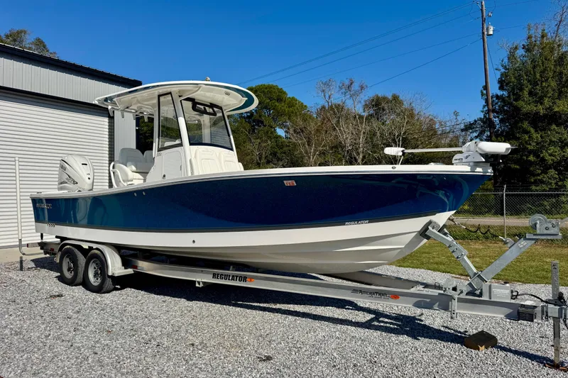 The Image of 2021 Regulator 26XO boat on trailer, parked outdoors near a building. - 1