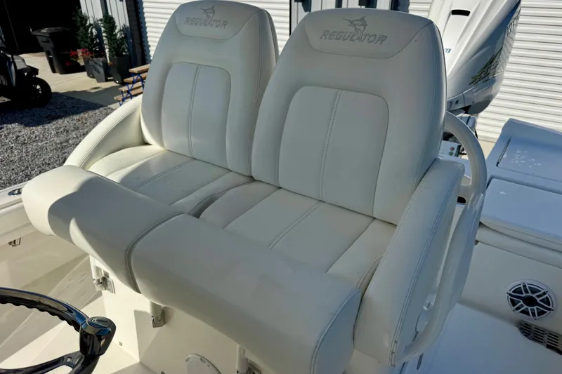 Slide: The Image of 2021 Regulator 26XO boat with dual white cushioned seats and steering wheel. - 11