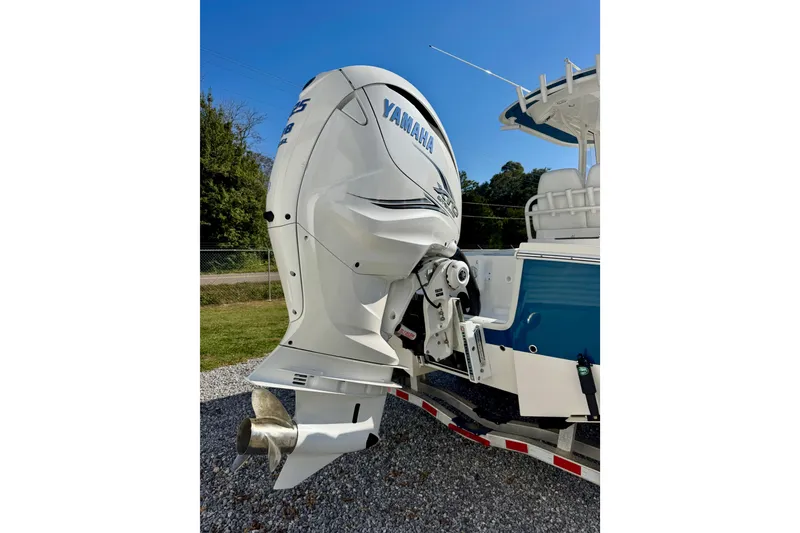 Slide: The Image of 2021 Regulator 26XO boat with Yamaha outboard motor, parked on gravel. - 4