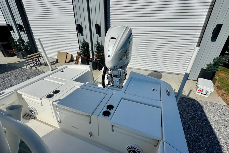 Slide: The Image of 2021 Regulator 26XO boat with outboard motor, docked near storage units. - 6
