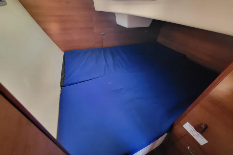 Slide: The Image of Interior cabin of 2013 Hunter 33 sailboat with blue bedding and wooden finish. - 10