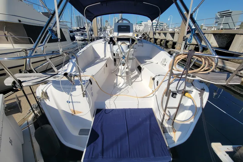 Slide: The Image of 2013 Hunter 33 sailboat cockpit with blue canopy, docked at marina. - 12