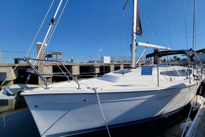 Slide: The Image of 2013 Hunter 33 sailboat docked at marina under clear blue sky. - 13