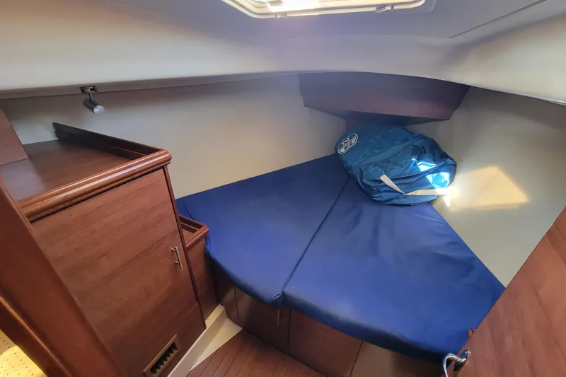 Slide: The Image of Cozy cabin interior of 2013 Hunter 33 sailboat with blue bedding and wooden cabinetry. - 8