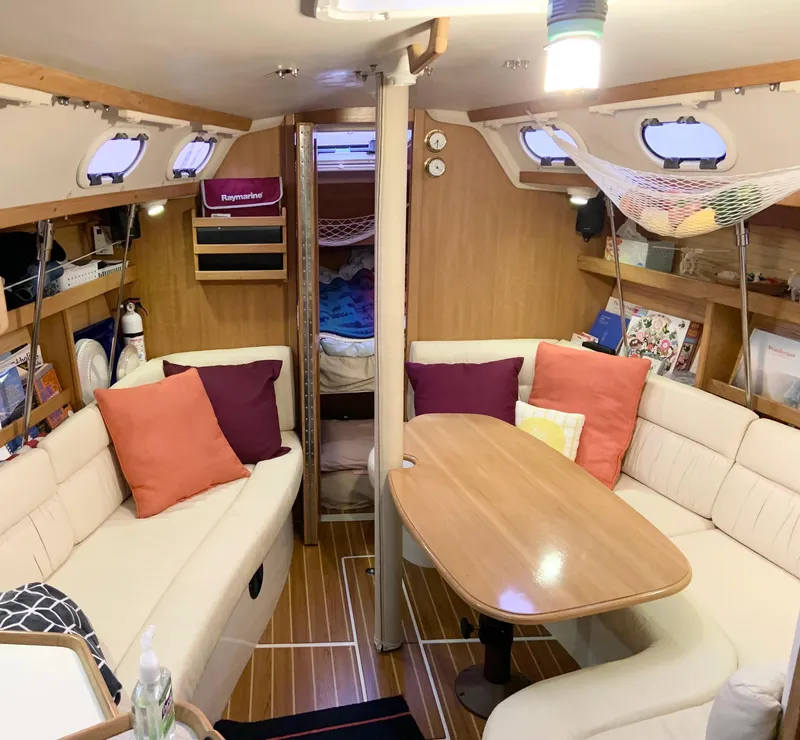 Slide: The Image of Interior of a 2005 Catalina 320 Sloop with cozy seating and colorful cushions. - 2