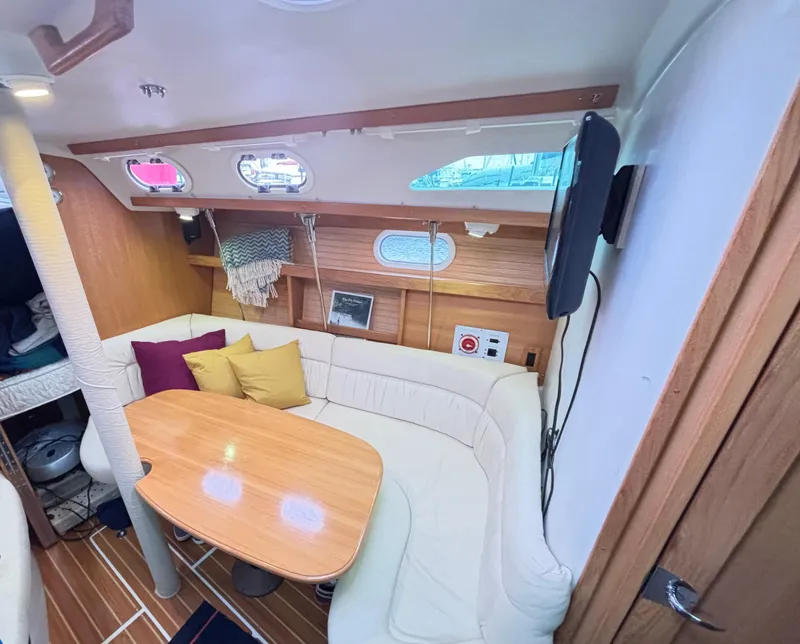 Slide: The Image of Interior of 2005 Catalina 320 Sloop with cozy seating and wooden table. - 3