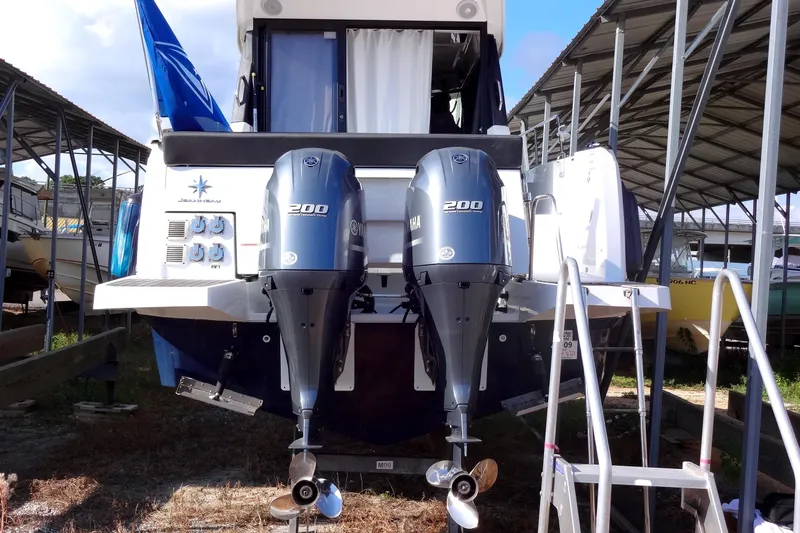 Slide: The Image of 2022 Jeanneau Merry Fisher 895 Offshore with dual Yamaha 200 engines in a covered marina. - 11
