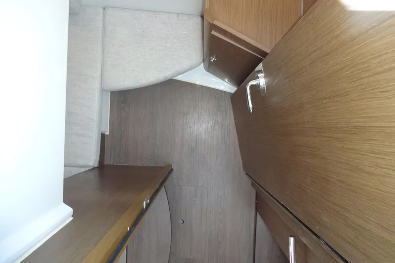 Slide: The Image of Interior of 2022 Jeanneau Merry Fisher 895 Offshore, featuring wood cabinetry and seating. - 112