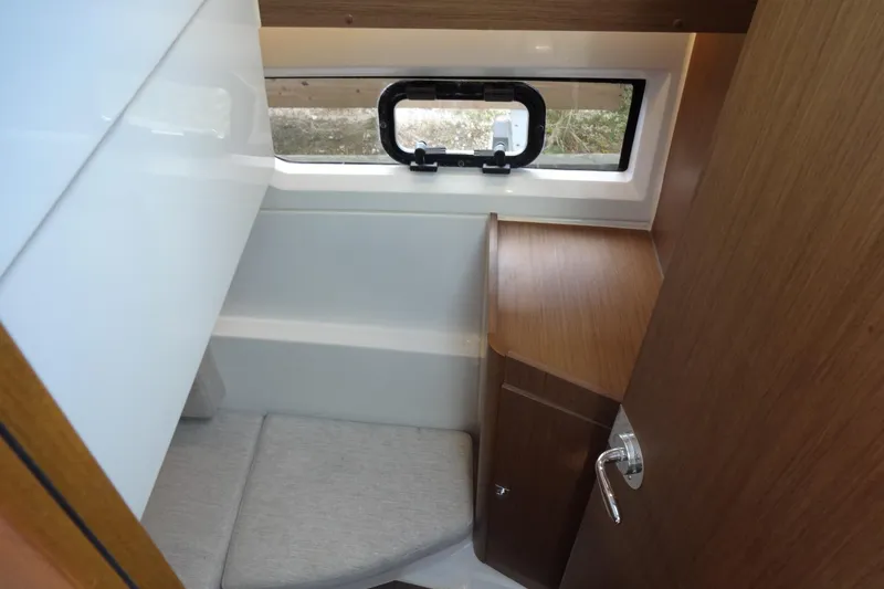 Slide: The Image of Interior cabin of 2022 Jeanneau Merry Fisher 895 Offshore, featuring wood finish and window. - 113