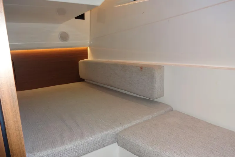 Slide: The Image of 2022 Jeanneau Merry Fisher 895 Offshore cabin interior with cushioned seating and ambient lighting. - 116