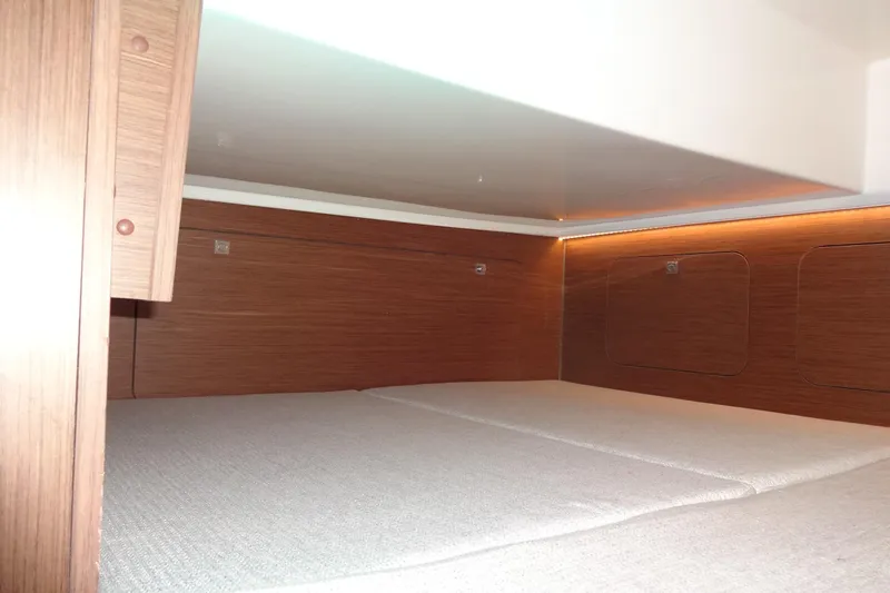 Slide: The Image of Interior cabin of 2022 Jeanneau Merry Fisher 895 Offshore, featuring wood paneling and cozy bedding. - 118