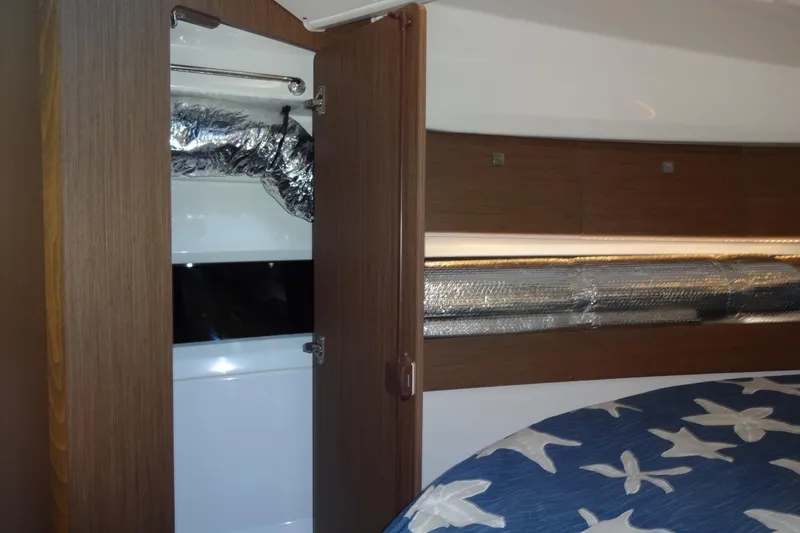 Slide: The Image of Interior of 2022 Jeanneau Merry Fisher 895 Offshore with wood finish and star-patterned bedding. - 129