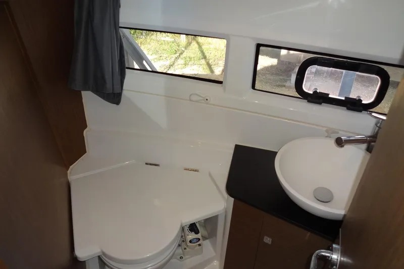 Slide: The Image of 2022 Jeanneau Merry Fisher 895 Offshore bathroom with sink, toilet, and window. - 136