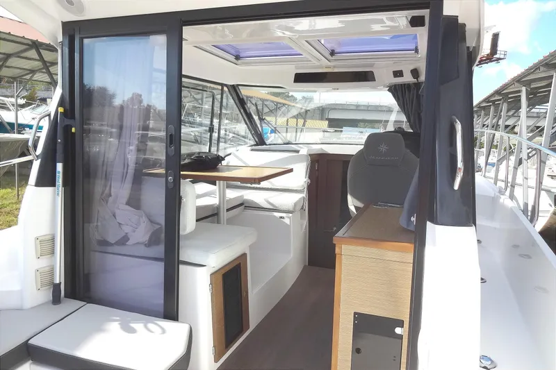 Slide: The Image of 2022 Jeanneau Merry Fisher 895 Offshore interior with seating and table, showcasing modern design. - 14