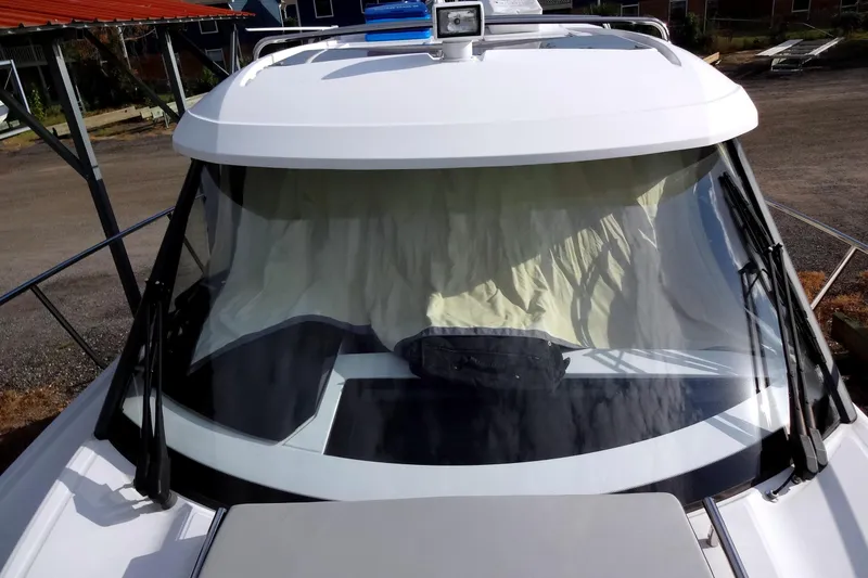 Slide: The Image of 2022 Jeanneau Merry Fisher 895 Offshore boat with covered windshield, docked outdoors. - 18