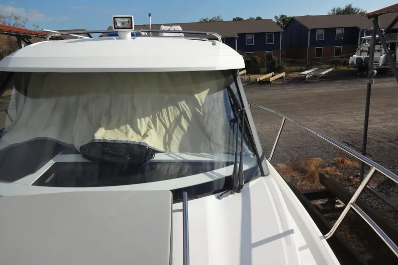 Slide: The Image of 2022 Jeanneau Merry Fisher 895 Offshore boat docked, front view with windshield and railings. - 20