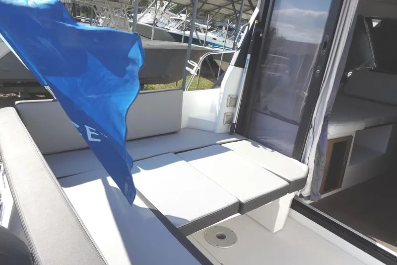 Slide: The Image of 2022 Jeanneau Merry Fisher 895 Offshore boat interior with seating and blue flag. - 22