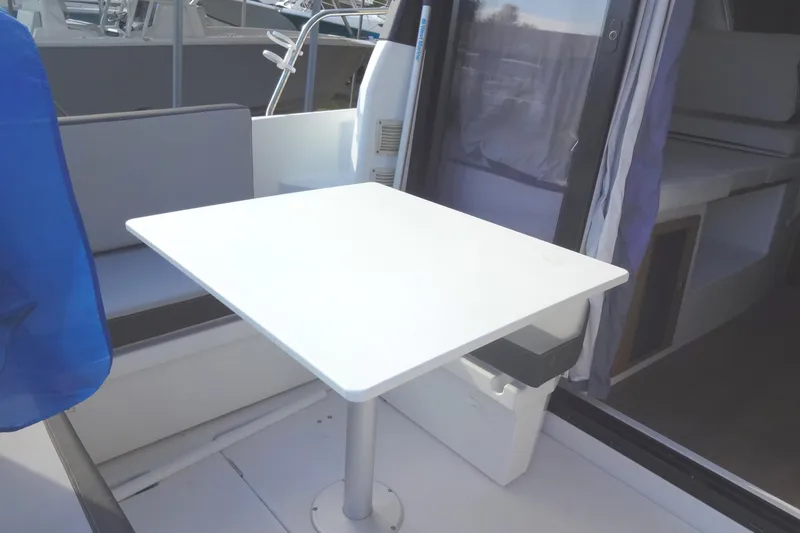 Slide: The Image of 2022 Jeanneau Merry Fisher 895 Offshore interior with white table and seating area. - 27