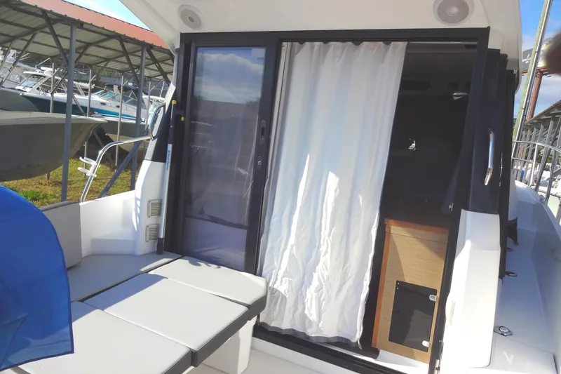 Slide: The Image of 2022 Jeanneau Merry Fisher 895 Offshore boat interior with sliding door and seating area. - 33