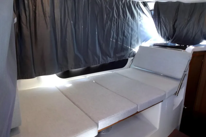 Slide: The Image of Interior of 2022 Jeanneau Merry Fisher 895 Offshore with cushioned seating and curtains. - 38