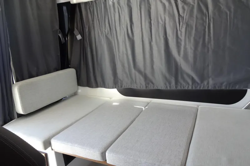 Slide: The Image of Interior seating area of 2022 Jeanneau Merry Fisher 895 Offshore with gray cushions and curtains. - 41