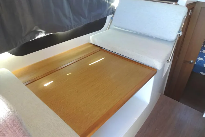 Slide: The Image of Interior of 2022 Jeanneau Merry Fisher 895 Offshore with wooden table and cushioned seating. - 44