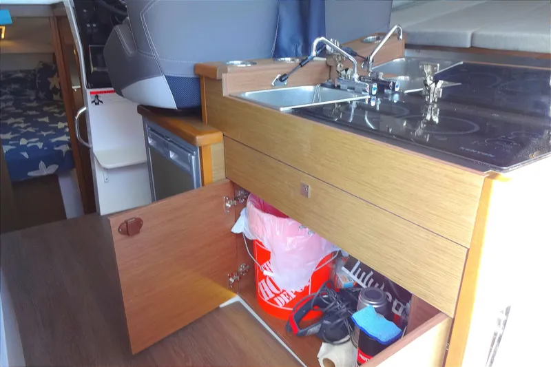 Slide: The Image of Interior of 2022 Jeanneau Merry Fisher 895 Offshore, featuring compact kitchen area. - 61