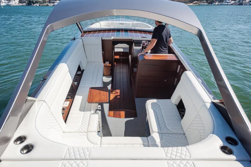 Slide: The Image of 2023 StanCraft 390 Hammerhead luxury boat interior with white seating and wooden accents. - 6