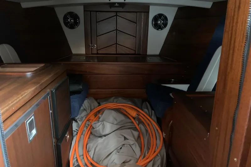 Slide: The Image of Interior of 2023 StanCraft 340 Darkside boat with wood finish and coiled orange hose. - 13