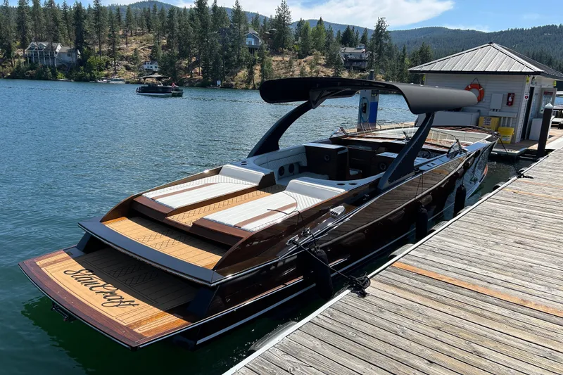 Slide: The Image of 2019 StanCraft 380 Hammerhead boat docked on a scenic lake with forested hills. - 3