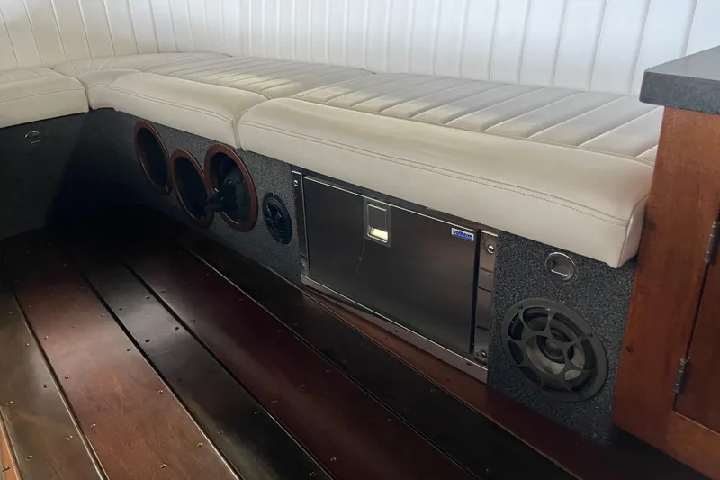 Slide: The Image of Interior of a 2013 StanCraft 34 Highboy Deluxe with white seating and wood flooring. - 15