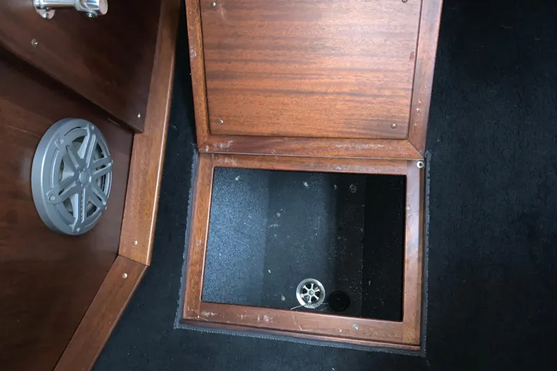 Slide: The Image of Open storage compartment in 2017 StanCraft 24 Highboy Surf boat with wooden finish. - 13