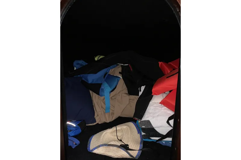 Slide: The Image of Storage compartment in a 2017 StanCraft 24 Highboy Surf boat with clothing and a hat. - 15