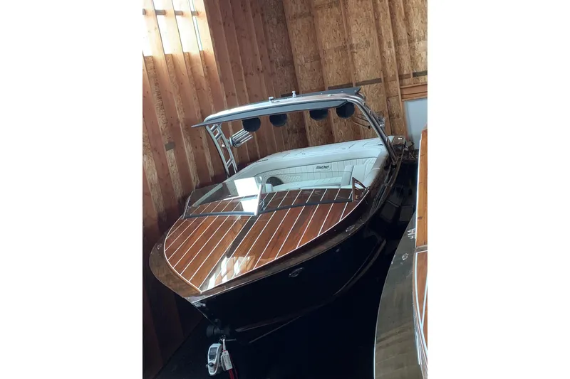Slide: The Image of 2017 StanCraft 24 Highboy Surf boat with sleek wooden deck in storage. - 3